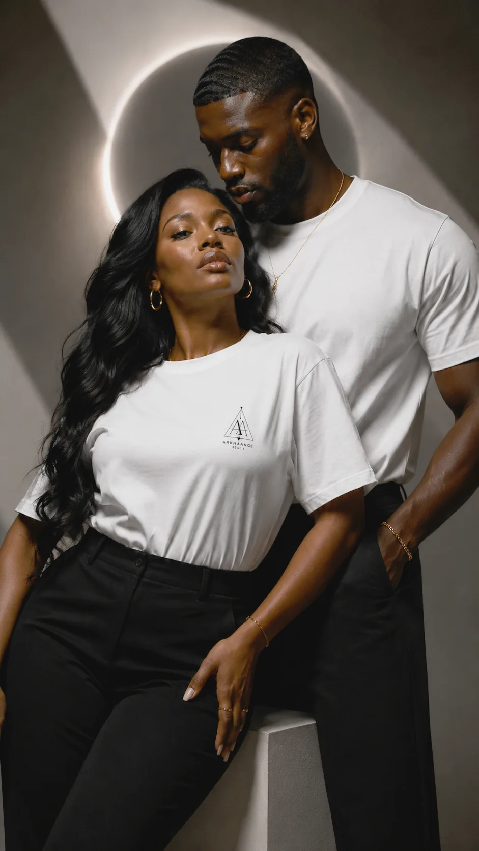 Two people in a dark studio, one turned toward the light.
